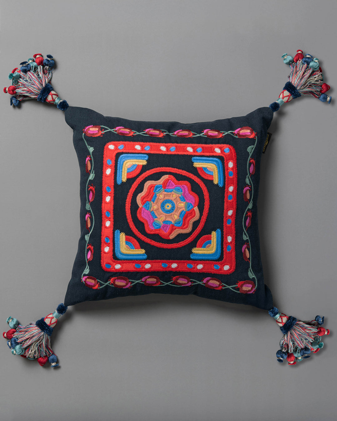 CARNIVAL embroidered cushion (LC40266) by Mind The Gap | LC40266 | TRANSYLVANIAN RHAPSODY | 50 x 50 cm / 20 x 20 in | Blue, Yellow, Pink, Red | Tasseled corners | Duck feather | 100% Linen | Fabric Carolina | https://www.fabriccarolina.com/